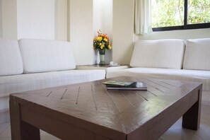 A living room with a sofa, a coffee table, and a vase with flowers. - Coral Vista del Mar (Ixtapa)