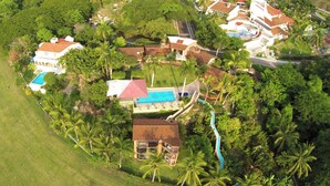 Ein Resort mit mehreren Gebäuden, einem Swimmingpool und üppiger Bepflanzung.
