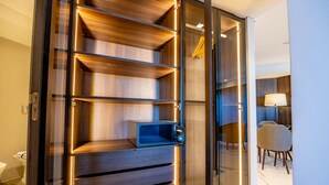 Ein modernes Hotelzimmer mit einem Holzschrank, einem Schreibtisch und einem Stuhl.
