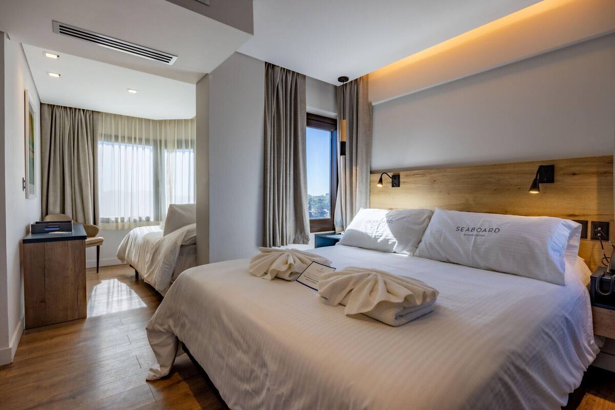 Una camera d'albergo moderna con un ampio letto, una scrivania e vista sulla città.