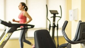 Un gimnasio con una cinta de correr y una máquina elíptica.