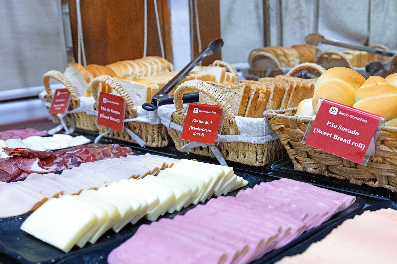Diversa variedad de pan y queso exhibidos en cestas con etiquetas.