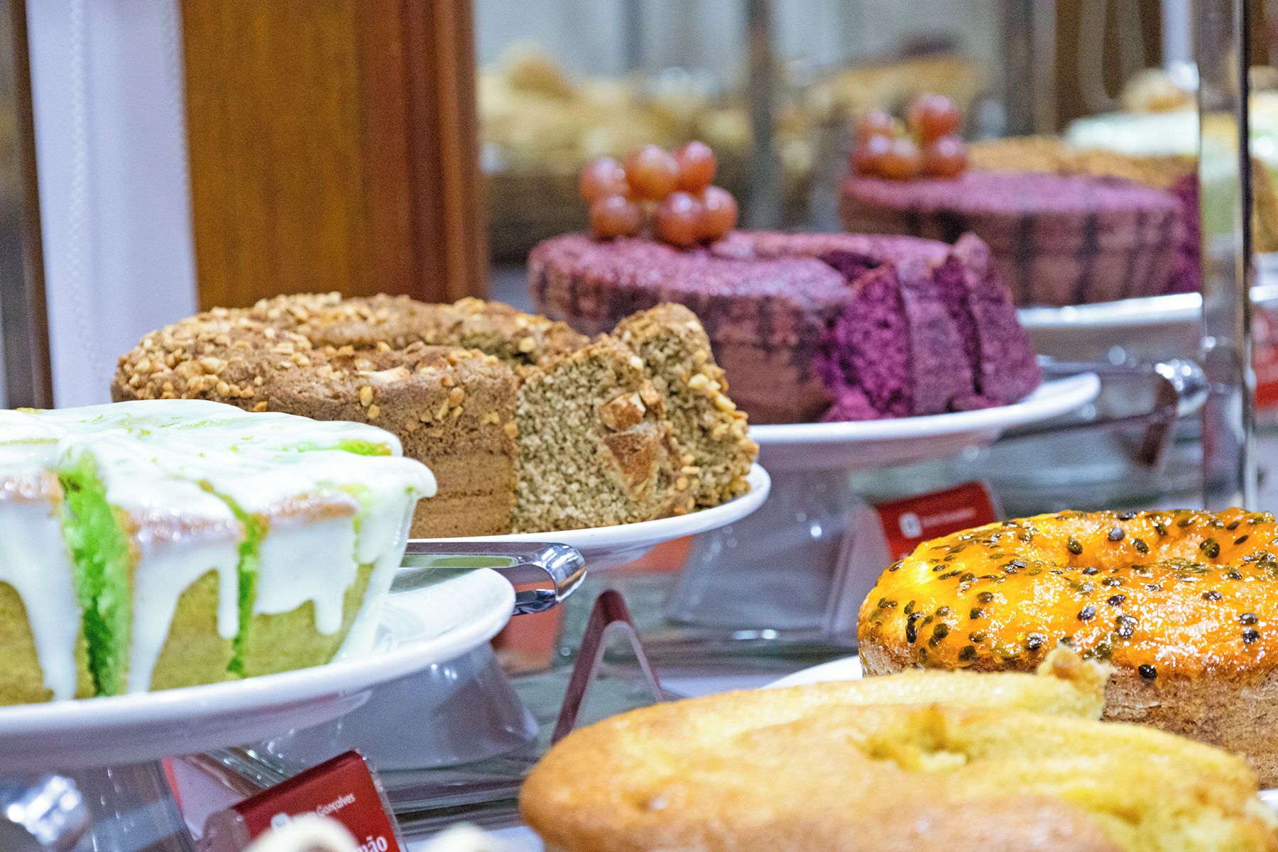 A variety of cakes displayed in a bakery setting.