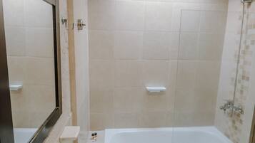Un baño con lavamanos, espejo, ducha y bañera.