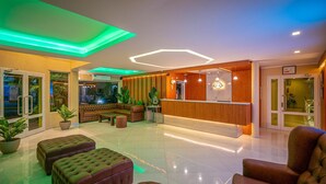 A modern lobby with a reception desk, plush seating, and potted plants. - Alto Verde Suites and Apart (Termas de Rio Hondo)
