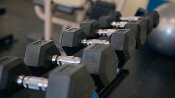 A row of black dumbbells on a rack. - Alto Verde Suites and Apart (Termas de Rio Hondo)