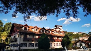 A large building with multiple balconies and a swimming pool area. - Hotel Floresta (Poços de Caldas)