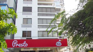 A multi-story building with a red awning labeled "Presto" and a sign for "La Habana." - Apartamento Arena - Smr236a (Santa Marta)