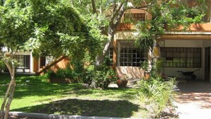A house with a covered patio, a small garden, and a window with bars. - Hotel La Ballena (Punta del Este)