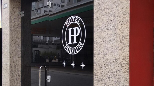 A hotel entrance with a large sign displaying the name and logo. - Hotel Podium (Sao Caetano do Sul)