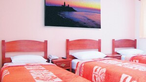 A hotel room with two beds, each with a red blanket and white pillow. There is a painting of a sunset on the wall above the beds. - Hotel Podium (Sao Caetano do Sul)