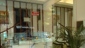 A lobby with a glass partition, a potted plant, and a sign indicating a private room. - Hotel Playa Suites CR (Mar Del Plata)