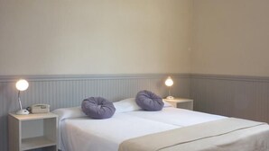 A simple, clean room with a bed, two nightstands, and two lamps. - Du Helder (Buenos Aires)