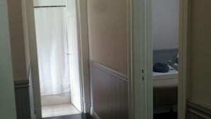 A narrow hallway with a dark wooden floor and white walls. - Du Helder (Buenos Aires)