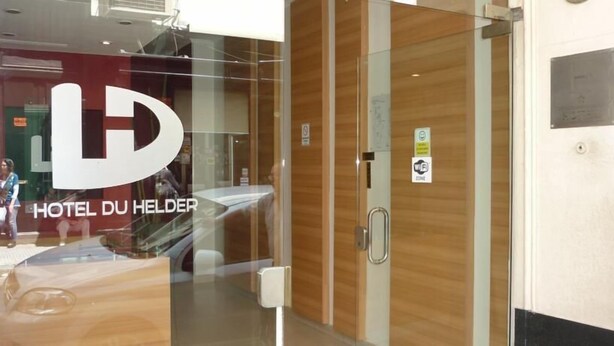 A hotel entrance with a glass door, a wooden interior, and a sign indicating a WiFi zone. - Du Helder (Buenos Aires)