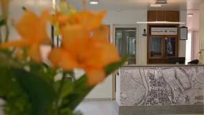 Una recepción con un mural de un mapa, un teléfono y un mueble de madera.