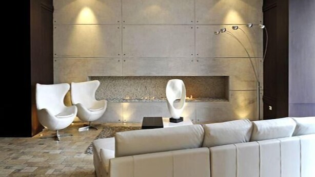 A modern living room with a fireplace, two white armchairs, and a beige sofa. - Ritz Plaza Suite (Quito)