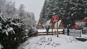 A snow-covered wooden fence with a sign that reads "CABANAS DEL TREbol." - Monoambiente del Trebol (San Carlos de Bariloche)