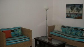 Ein Wohnzimmer mit zwei Sofas, einem Couchtisch und einem Gemälde an der Wand.