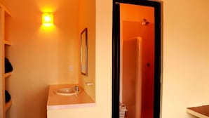 A bathroom with a sink, mirror, and a wall-mounted light fixture. - Rivera del Mar (Puerto Escondido)