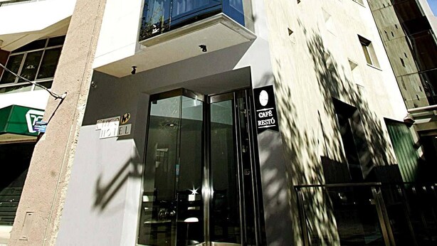 A modern high-rise building with a glass facade and a ground-level entrance.