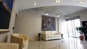 A modern lobby with a white sofa, a large abstract painting, and a bicycle.