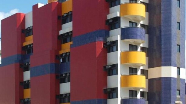 Un hotel de varios pisos con una fachada distintiva de bloques de color, que presenta paneles amarillos, rojos y azules.
