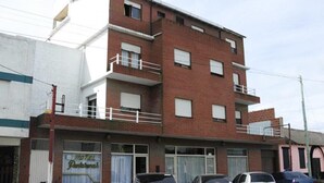 Un edificio de varios pisos con un restaurante en la planta baja llamado "Hotel Dantares".