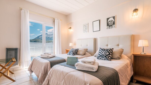 Ett hotellrum med två sängar, en balkong och utsikt över bergen.