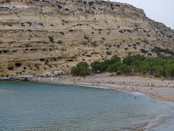 A coastal beach with rocky cliffs and a clear view of the sea. - Hotel Calypso (Faistos)