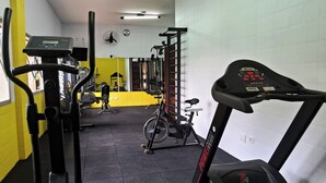 Un gimnasio con diversos equipos de ejercicio, incluyendo cintas de correr y máquinas de pesas.