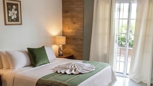 A hotel room with a bed, a nightstand, a lamp, a framed picture, and a window with curtains. - Altas Cumbres Hotel & Apart (Villa Carlos Paz)