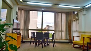 A living room with a dining area, large windows, and a view of the city. - Torre los Platanos (San Miguel de Tucumán)