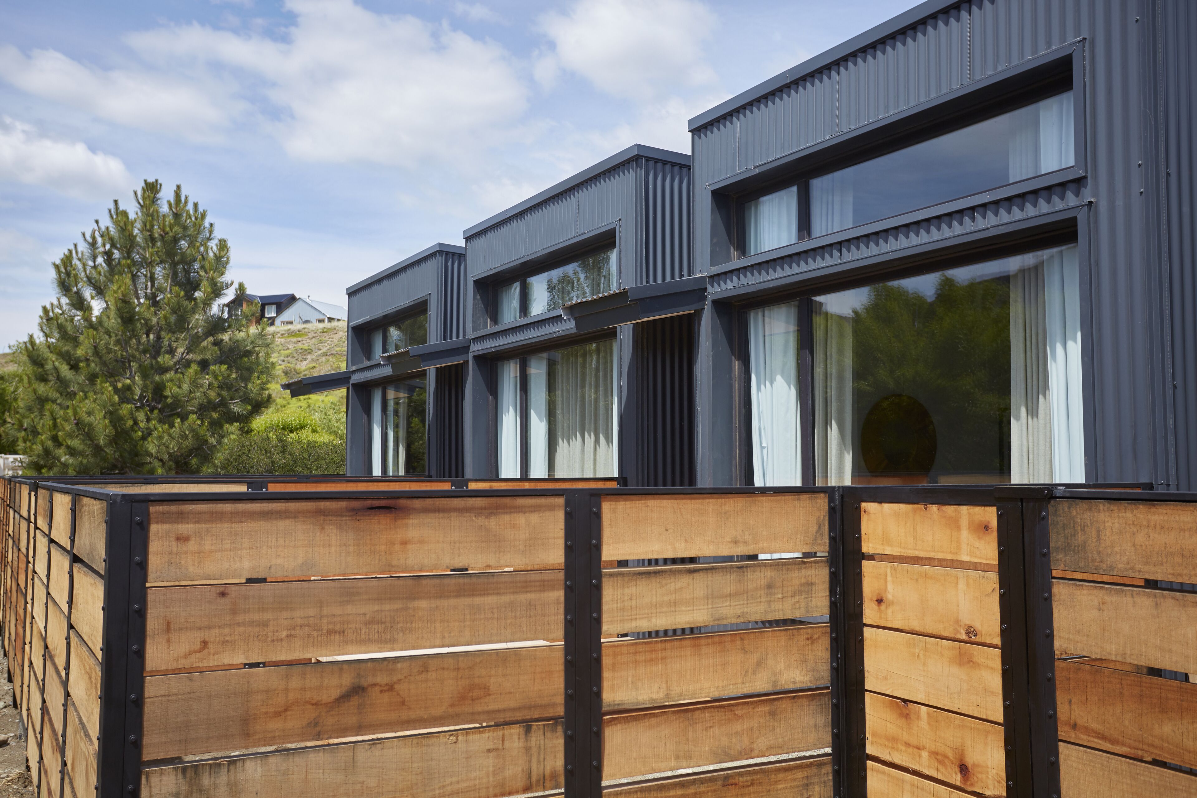 A modern building with a wooden fence and large windows.