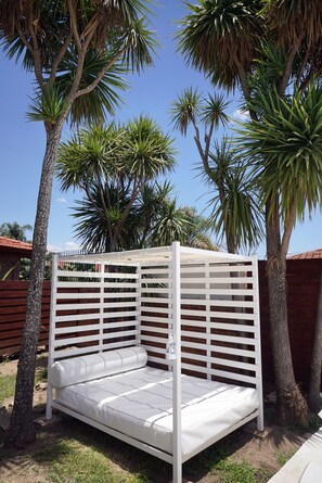 Una piscina al aire libre, sombrillas, sillones reclinables de piscina