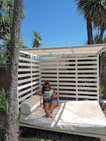 Una piscina al aire libre, sombrillas, sillones reclinables de piscina