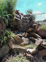 Una piscina al aire libre, sombrillas, sillones reclinables de piscina