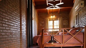 A loft-style bedroom with a wooden ceiling, a bunk bed, and a kitchen area with a sink and cabinets. - Cabañas la Aldea (Villa Carlos Paz)