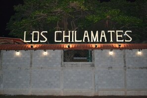 A sign with the text "LOS CHILAMATES" illuminated against a night sky. - Hotel Los Chilamates (Granada)