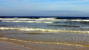 A beach with waves approaching the shore.