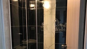 Un baño moderno con ducha envuelta en vidrio, inodoro y tocador.