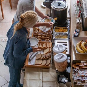 A buffet setup with various food items and a coffee machine.