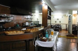 Un restaurante con mesas de buffet, que ofrece una variedad de alimentos y bebidas.