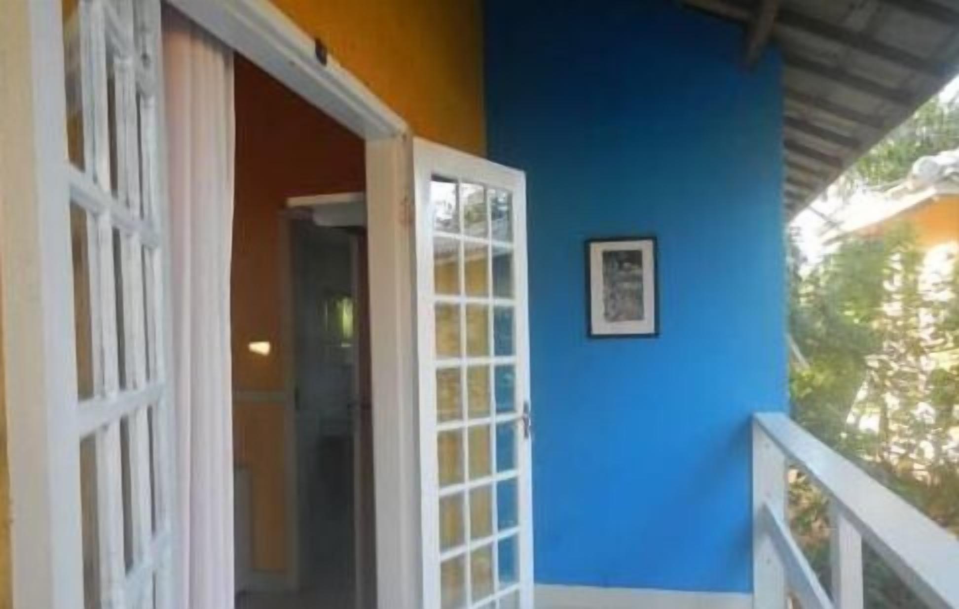 A room with a blue wall, a white door, and a framed picture on the wall.