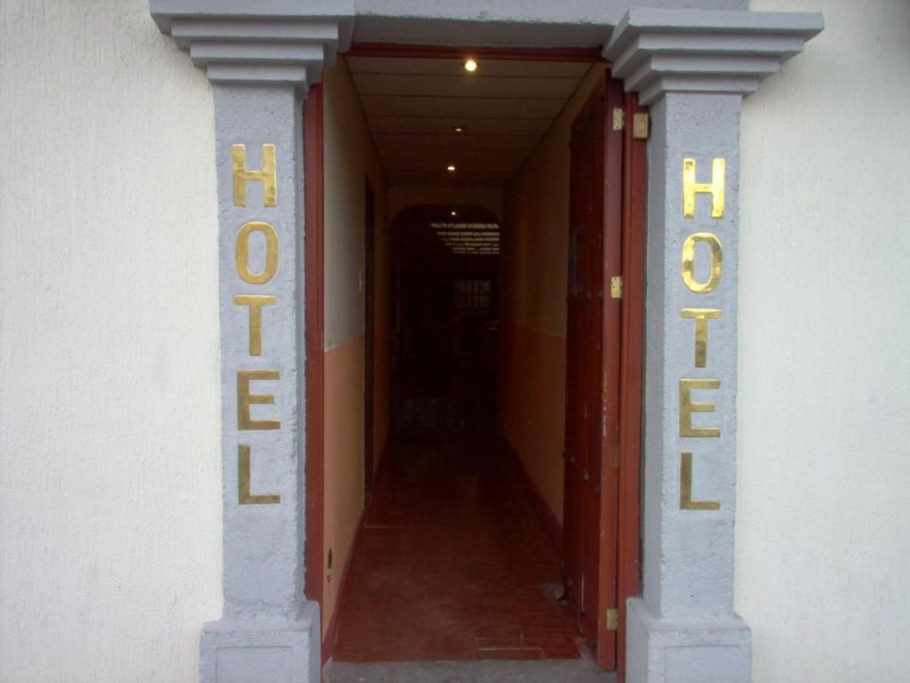 Een hotel ingang met een gang die naar het donkere interieur leidt.