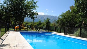 A swimming pool with a view of mountains in the background. - Apart Hotel Camino del Cerro (Merlo)