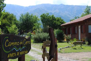 A rustic building with a sign reading "Camino del Cerro Apartes de Montaña." - Apart Hotel Camino del Cerro (Merlo)