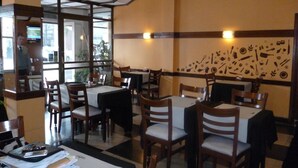 Ein Restaurantinnenraum mit Tischen und Stühlen, einer Wand mit Illustrationen von Speisen und Getränken und einem Schild mit der Aufschrift "Love Guatemala".