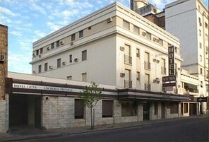 Un edificio histórico con un estilo arquitectónico clásico, que presenta una fachada plana, ventanas simétricas y una entrada destacada con un letrero que dice "HOTEL VIECHA".