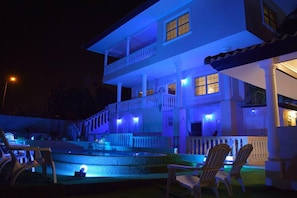 Un bâtiment à deux étages doté d’un balcon, d’une piscine et d’un espace extérieur aménagé pour s’asseoir.